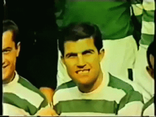 two men in green and white shirts standing together
