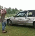 a person standing next to an abandoned car