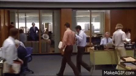 several men are walking in an office lobby