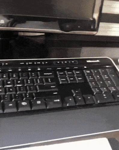 a black computer keyboard sitting on top of a desk