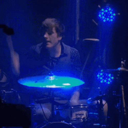 a drummer performing in an audience at a concert