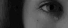 a woman's tear on her eye looking out the window