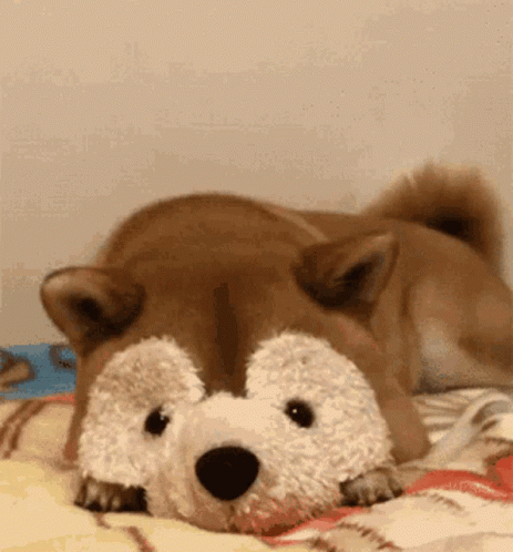 a stuffed animal laying on the bed with the pillow