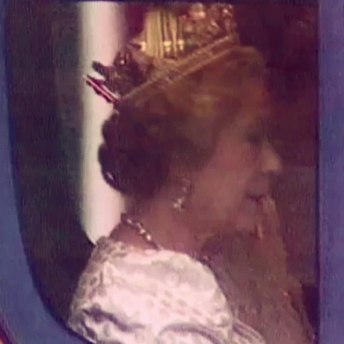 woman with a crown sitting and staring out of window