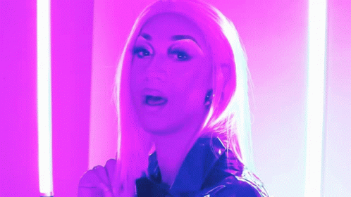 a blond woman with large  standing in pink light