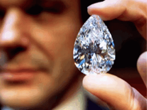 a man holding a diamond in one hand and a blue face behind him
