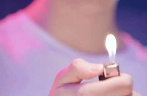 someone holding up a tiny lighter in front of their face