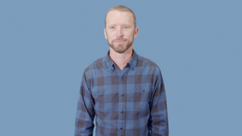 a man in plaid shirt holding soing and standing