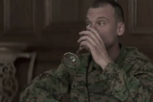 a soldier drinking soing with a wine glass