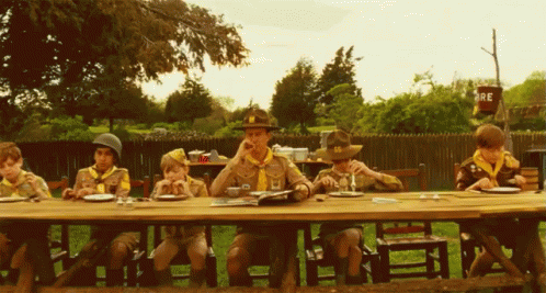 a group of children sitting at a table eating