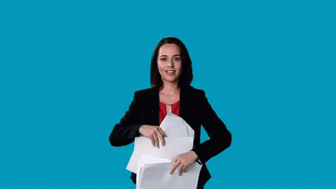 woman in business outfit holding open large piece of paper