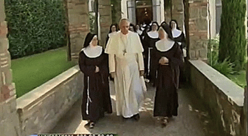 the nun women in white are walking through the building