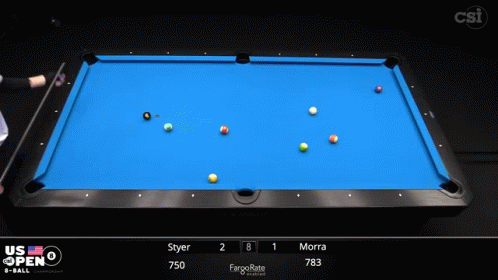 the hand is holding a pool cue while the ball is laying on top of the table