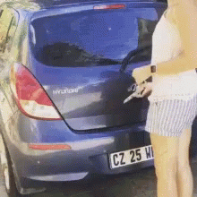 a woman opening a car door while another girl tries to h the door