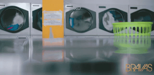an empty laundry washer with green laundry basket