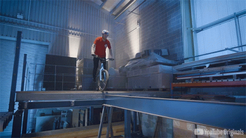 a man rides a bike in a large warehouse