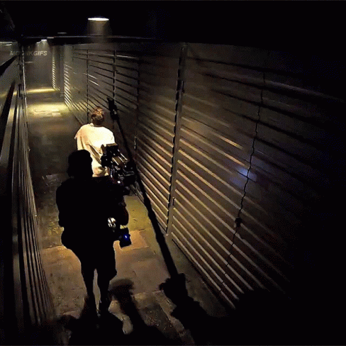 man walking in a dark hallway with his bike
