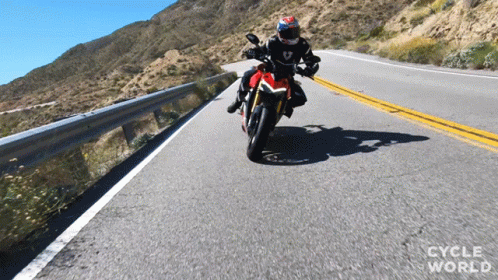 person riding a motorcycle on a mountain road