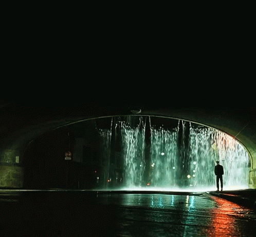 the person is standing in front of a water fountain