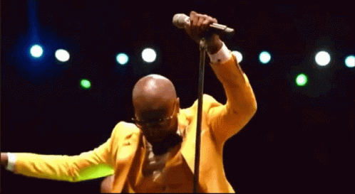 a man in blue holding a microphone and dancing