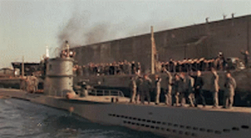 several military people stand on a ship
