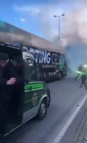a bus driving down a road with dust coming from it