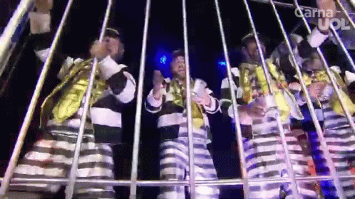 group of young people dressed in clown costume sitting inside a metal cage