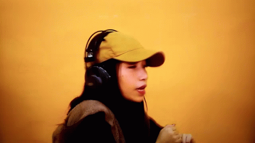 a young man wearing headphones while he looks at soing