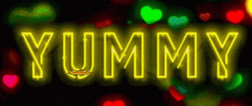 the words yummy are neon blue in front of brightly colored lights
