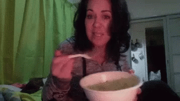 a lady holding a large bowl with some green liquid in it