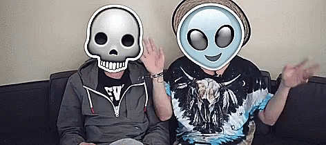 two people sitting next to each other while one person has a weird mask