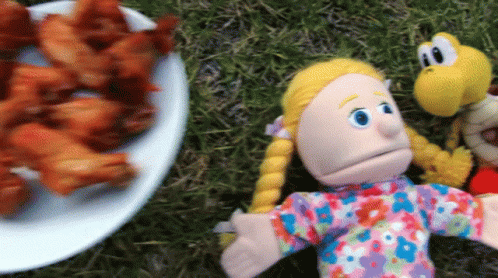 a blue stuffed animal and a toy doll lying on the ground