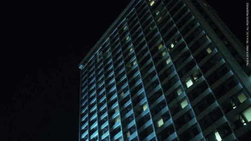 a very tall building at night with a lot of windows