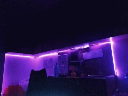 an open kitchen with pink lights in the corner