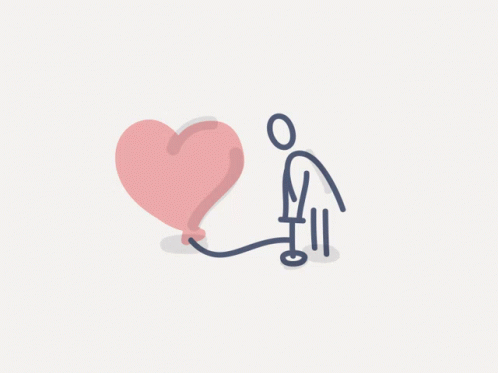 a man is holding a blue heart that is attached to a cord