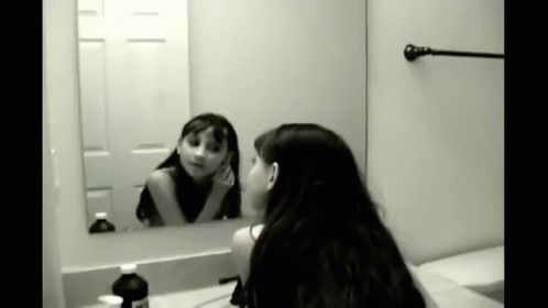 woman in the bathroom with mirror looking at her hair