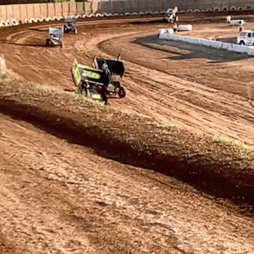 a dirt track with two vehicles going around it