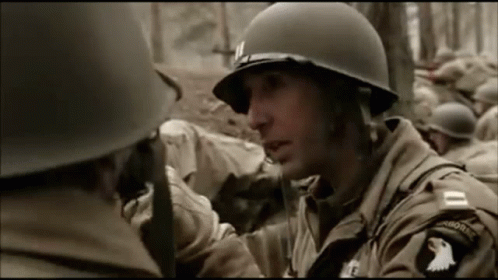 a soldier talks to another man on a cell phone