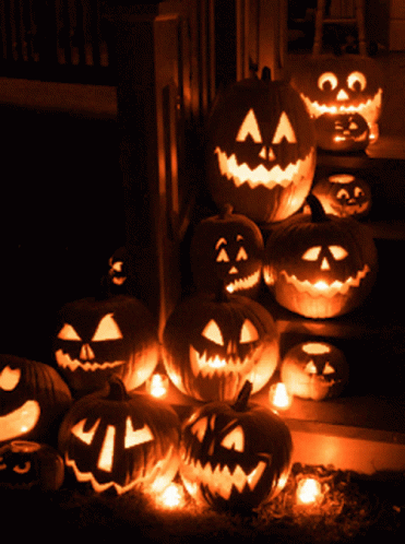 pumpkins all lit up in the dark by halloween lights