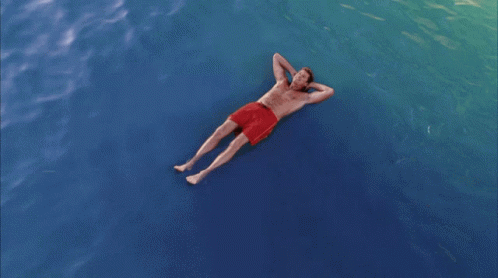 the man is floating on his stomach in the water