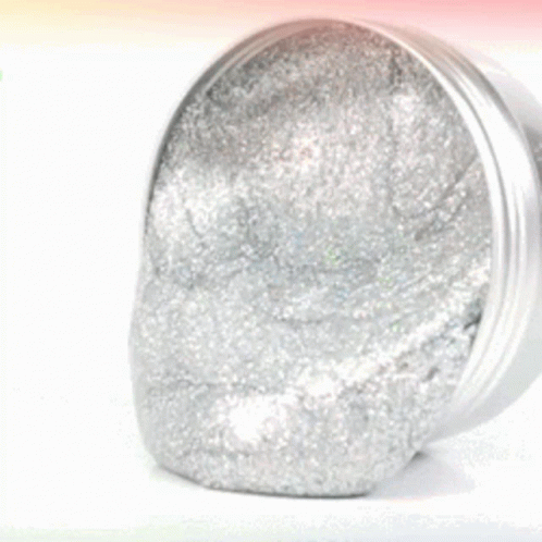 a metal jar of silver glitter is against a light blue background