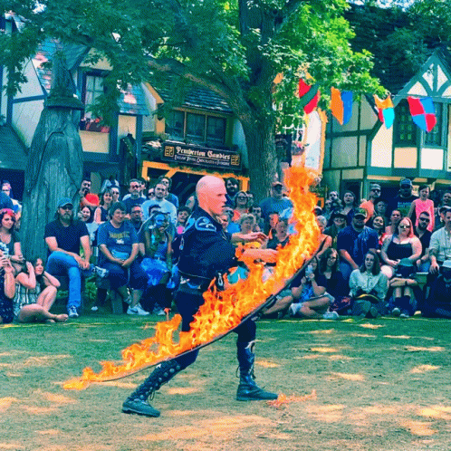 two men in costumes and one with fire on his head are performing a dance
