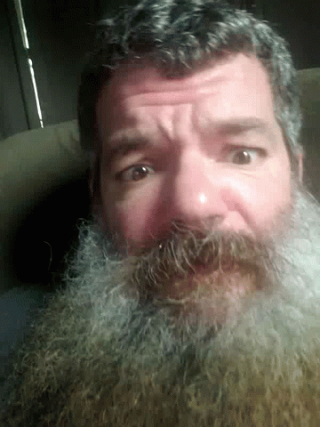 an old man with a beard stares straight ahead