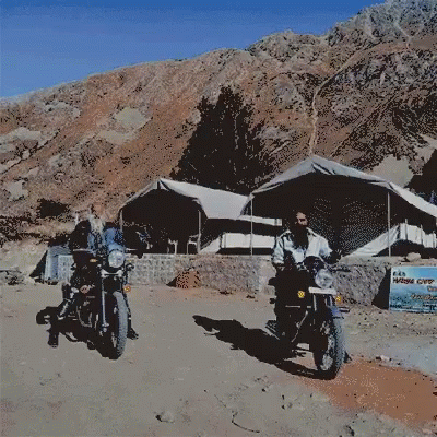 two motorcyclists riding on dirt road during daytime