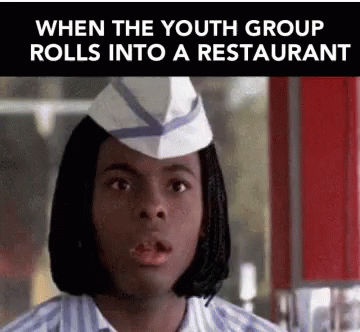 a woman wearing a hat with an advertit reading when the youth group rolls into a restaurant