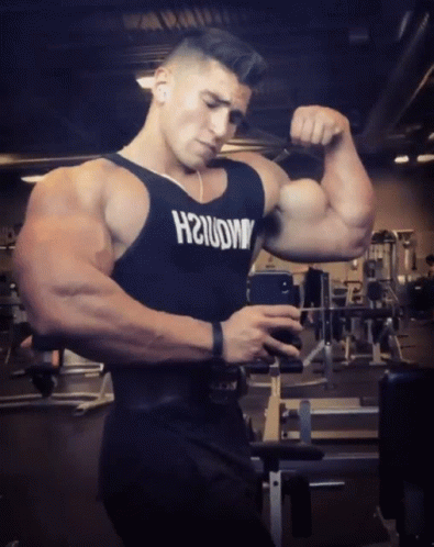 a bodybuilding athlete holding his arms in the gym