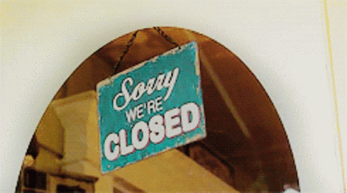 an image of a closed sign with a house and roof in the background