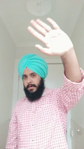 man in yellow turban waving out his left hand