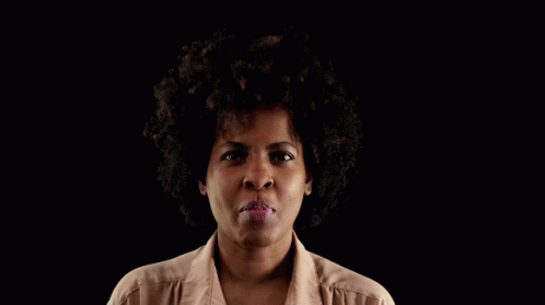 a black woman wearing a white shirt has her mouth open