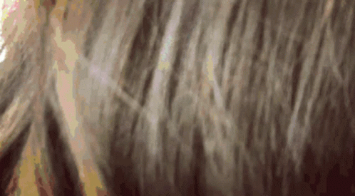 blurry image of a woman with hair blowing in the wind